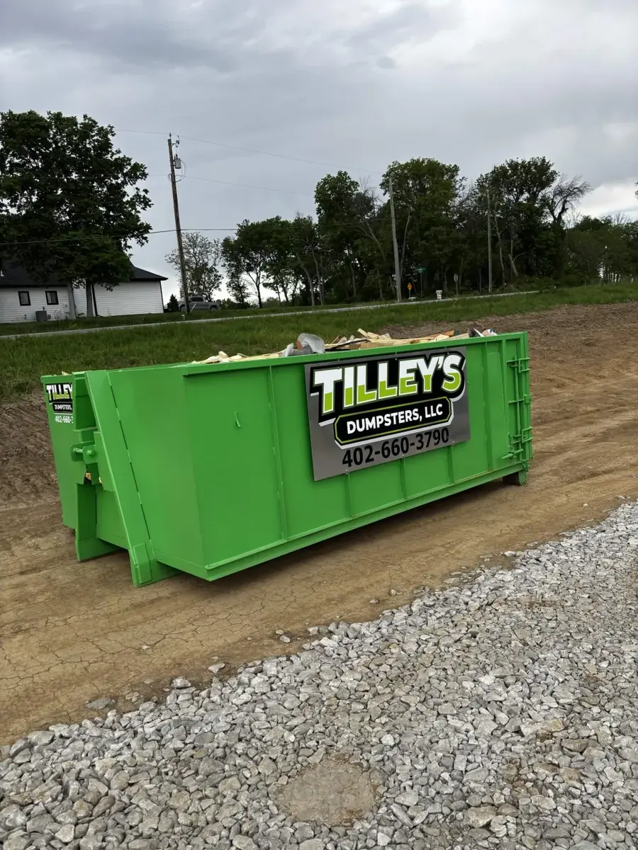 10 yard green Tilley's roll-off dumpster on a job site