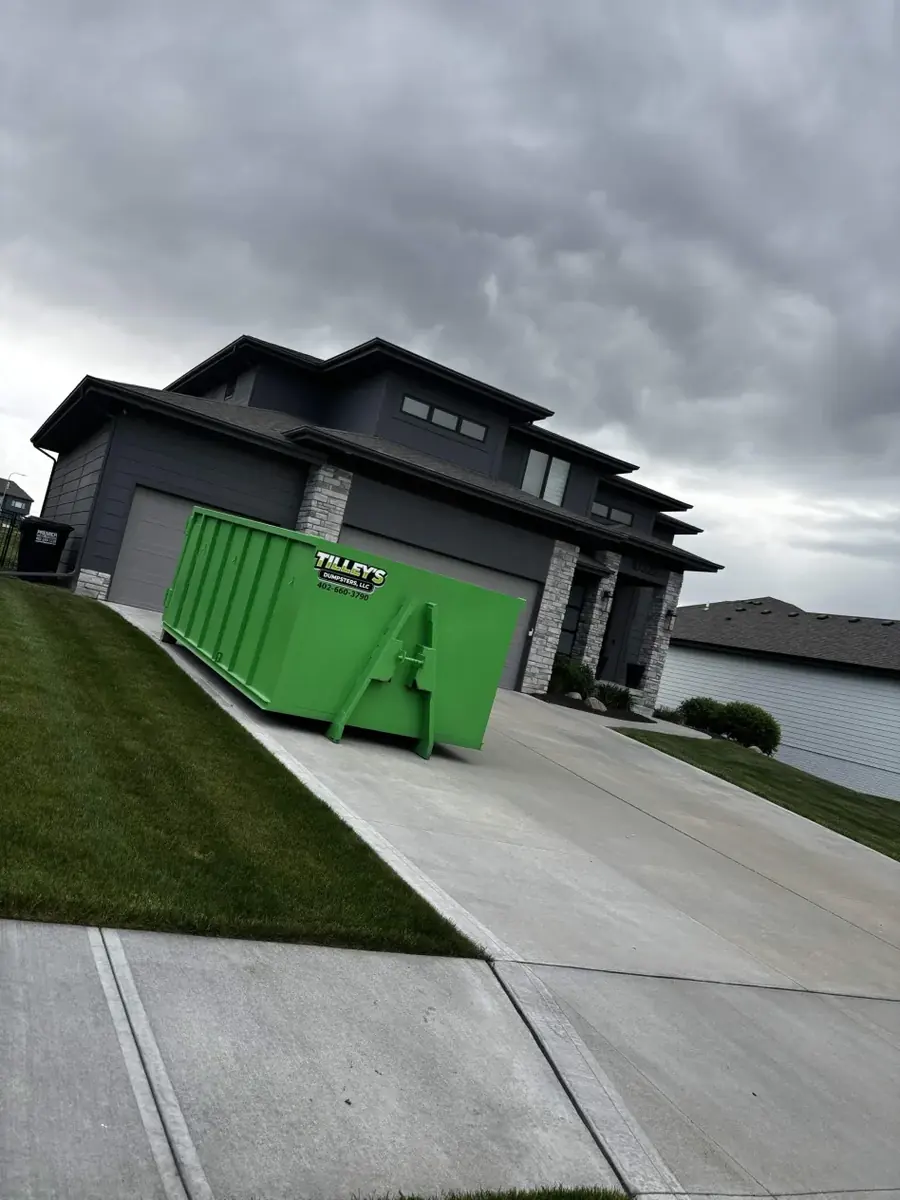 20 yard green Tilley's roll-off dumpster on a job site